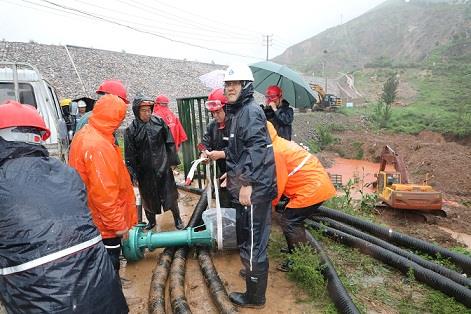 圖一為中州鋁業(yè)保障中心員工冒雨在現(xiàn)場(chǎng)搬運(yùn)潛水泵設(shè)備，以應(yīng)對(duì)未來幾天更加嚴(yán)峻的汛情。